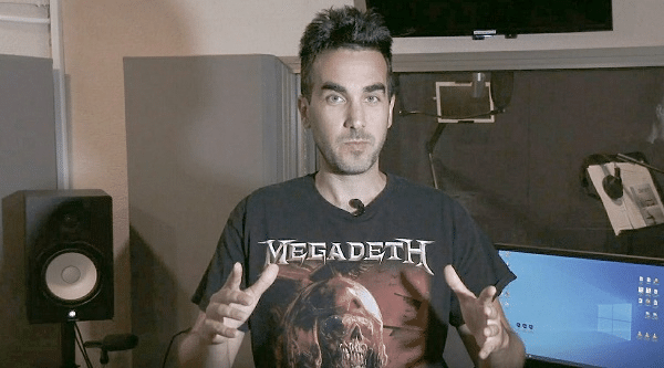 גבר בחולצת MEGADETH מדבר ומחווה בידיו באולפן הקלטות